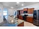 Modern kitchen with stainless steel appliances, beautiful granite countertops, and wooden cabinets at 176 Blackstone Creek Rd, Groveland, FL 34736