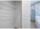 This is a walk-in closet with white shelving, a wood floor, and a view of the bathroom with a shower at 176 Blackstone Creek Rd, Groveland, FL 34736