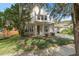 Charming two-story home with manicured lawn, mature trees, and covered front porch entry at 226 W Tarrington Dr, Deland, FL 32724