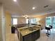 Open-concept living space featuring a kitchen island, inviting living room, and adjacent screened patio at 226 W Tarrington Dr, Deland, FL 32724