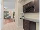 Home wet bar features dark cabinets, granite countertop, wine wrack, and tile flooring at 226 W Tarrington Dr, Deland, FL 32724