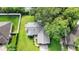 Aerial view of the home featuring a well-manicured lawn, mature trees, and a fenced backyard at 304 Hibiscus St, Chuluota, FL 32766