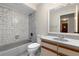 Bathroom with shower and tub combo, gray tile and gray cabinets at 304 Hibiscus St, Chuluota, FL 32766