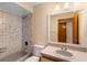 Bathroom featuring a tub shower, neutral tile, and sink vanity with a mirror reflecting an open doorway at 304 Hibiscus St, Chuluota, FL 32766
