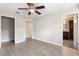 Bright bedroom features sleek gray floors, ceiling fan, and access to the ensuite bathroom at 304 Hibiscus St, Chuluota, FL 32766