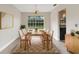 Bright dining room features a large window, wood floors, six chairs and stylish contemporary light fixture at 304 Hibiscus St, Chuluota, FL 32766