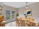 Dining room with light wood floors, glass patio doors, contemporary art and seating for six at 304 Hibiscus St, Chuluota, FL 32766