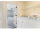 Bright laundry room features a washer, dryer and storage shelf, plus a view to the garage at 304 Hibiscus St, Chuluota, FL 32766