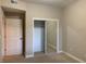 Carpeted bedroom features large mirrored closet and entry to the hallway at 6312 Buford St # 304, Orlando, FL 32835