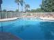 Community pool surrounded by mature trees and a white fence at 6312 Buford St # 304, Orlando, FL 32835