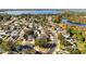 Scenic aerial view of a residential neighborhood with mature trees, winding streets, and a beautiful lake in the background at 7305 Grotto Ave, Orlando, FL 32812