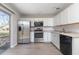 Remodeled kitchen featuring stainless steel appliances, white cabinets, and granite countertops at 962 Oropesa Ave, Orlando, FL 32807