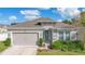 One-story house featuring gray siding, a two-car garage, and well-manicured landscaping at 1162 Alder Tree Dr, Apopka, FL 32703