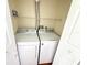 Efficient laundry room features a modern white washer and dryer with shelving above at 13803 Fairway Island Dr # 1627, Orlando, FL 32837