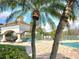 Scenic pool area with palm trees, brick flooring, and a covered pavilion with lounge seating at 13803 Fairway Island Dr # 1627, Orlando, FL 32837