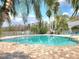 Community pool features brick trim and lounge chairs, with a fenced view of a scenic lake at 13803 Fairway Island Dr # 1627, Orlando, FL 32837