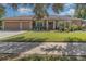 Tan house with three car garage and manicured lawn at 290 Thomas Dr, Casselberry, FL 32707