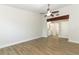 Large bedroom with wood-look floors and a ceiling fan; view of en suite bathroom at 666 Sausalito Blvd, Casselberry, FL 32707