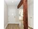 Inviting entryway featuring wood-look floors, a dark wooden support beam and white doors at 666 Sausalito Blvd, Casselberry, FL 32707