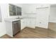 Bright kitchen with white cabinetry, stainless steel dishwasher, and wood-look floors at 666 Sausalito Blvd, Casselberry, FL 32707