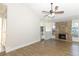 Spacious living room features a stone fireplace, ceiling fan and wood-look floors at 666 Sausalito Blvd, Casselberry, FL 32707