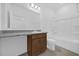 Bathroom featuring granite counters, wood cabinets, and a shower and tub combo at 8626 Caribbean Pine Way, Lakeland, FL 33809