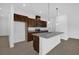 Kitchen island with stainless appliances, stone counters, pendant lights and dark wood cabinets at 8626 Caribbean Pine Way, Lakeland, FL 33809