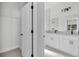 Bright bathroom with double sinks, white cabinets, and black hardware fixtures at 30 Fisher Trail, Ocklawaha, FL 32179