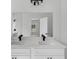 Bathroom features double sinks with black faucets, white cabinets, and large mirrors at 30 Fisher Trail, Ocklawaha, FL 32179