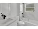 Well-lit bathroom with white tile, quartz countertop, black faucet, and bathtub with shower at 30 Fisher Trail, Ocklawaha, FL 32179