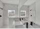 Modern bathroom features double sinks, black waterfall faucets, and unique tiled walls at 30 Fisher Trail, Ocklawaha, FL 32179