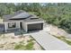 Aerial front view of home with a long driveway and two car garage at 30 Fisher Trail, Ocklawaha, FL 32179