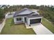 New construction features a dark roof, a two-car garage, and a green lawn at 30 Fisher Trail, Ocklawaha, FL 32179