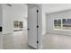 Spacious living room with bright white paint and light-colored floors leads to a separate room at 30 Fisher Trail, Ocklawaha, FL 32179