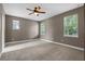 Neutral-toned primary bedroom with multiple windows, carpet flooring, and lots of natural light at 41 E Spruce St, Orlando, FL 32804