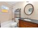 Charming bathroom featuring a tub with shower, decorative mirror, and a vanity with a black countertop at 3703 Pembrook Dr, Orlando, FL 32810