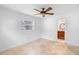 Bedroom featuring tiled floors, a ceiling fan, and a window with an adjacent doorway to the ensuite bathroom at 3703 Pembrook Dr, Orlando, FL 32810