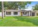 Inviting single-story residence with a yellow door, well-kept lawn, and mature trees in the front yard at 3703 Pembrook Dr, Orlando, FL 32810