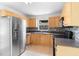 Traditional kitchen featuring stainless steel appliances and wood cabinets with dark countertops and tiled backsplash at 3703 Pembrook Dr, Orlando, FL 32810