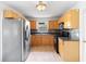 Traditional kitchen featuring stainless steel appliances and wood cabinets with dark countertops and tiled backsplash at 3703 Pembrook Dr, Orlando, FL 32810