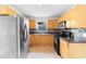 Traditional kitchen featuring stainless steel appliances and wood cabinets with dark countertops and tiled backsplash at 3703 Pembrook Dr, Orlando, FL 32810