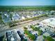 Aerial view of a neighborhood with well-maintained homes, lush trees, and a shopping center nearby at 535 Crimson Ln, Winter Springs, FL 32708