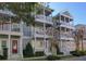 Charming townhome exterior with multiple balconies, white pillars, red doors, and well-maintained landscaping at 535 Crimson Ln, Winter Springs, FL 32708