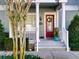 Inviting front entrance with red door, white columns, and landscaping at 535 Crimson Ln, Winter Springs, FL 32708