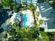 Aerial view of a community pool surrounded by palm trees, lush landscaping, and well-maintained buildings at 535 Crimson Ln, Winter Springs, FL 32708