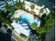 Aerial view of a community pool with palm trees, lounge chairs, and a white-roofed cabana at 535 Crimson Ln, Winter Springs, FL 32708