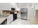 Bright kitchen featuring stainless steel appliances, white cabinets, and tile backsplash at 5418 S Bracken Ct, Winter Park, FL 32792