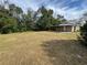 Large backyard with grassy area and covered patio at 620 Oak St, Auburndale, FL 33823