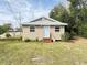 Tan single story home with light blue door and small yard at 620 Oak St, Auburndale, FL 33823