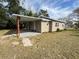 Newly remodeled tan house with carport and landscaping at 620 Oak St, Auburndale, FL 33823